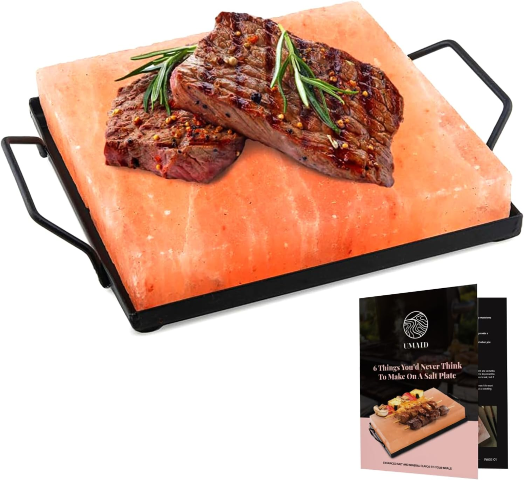 A Himalayan salt block with grilled steaks resting on top, garnished with rosemary, displayed on a black serving rack alongside an informational booklet.
